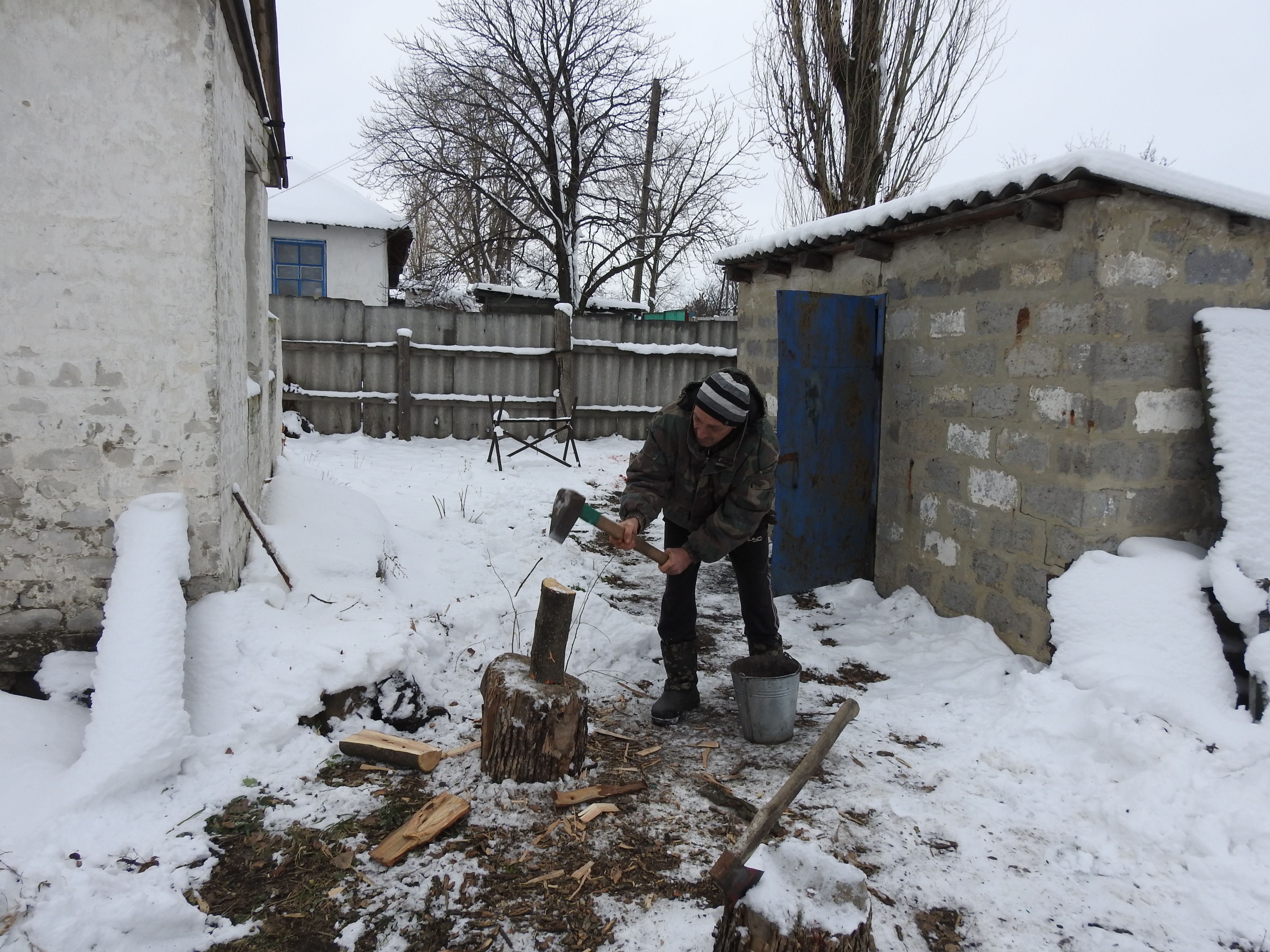 Yurii lives in a very small village, Druzhba on the frontlines of the Ukrainian conflict. Here he's preparing firewood for winter. ©NRC