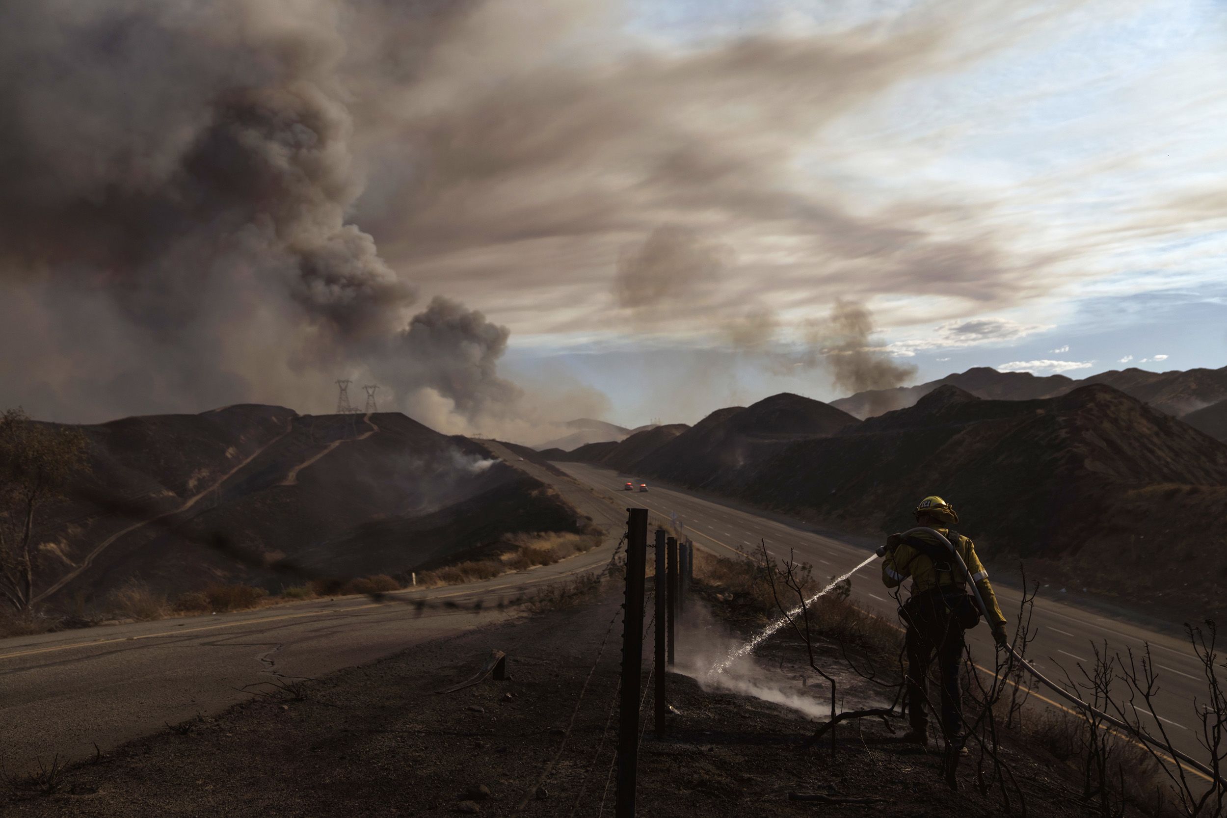 A firefighter battles a fast-growing brush fire which forced evacuations and the closure of a freeway near Los Angeles, California. ©Eric Thayer/Bloomberg via Getty Images
