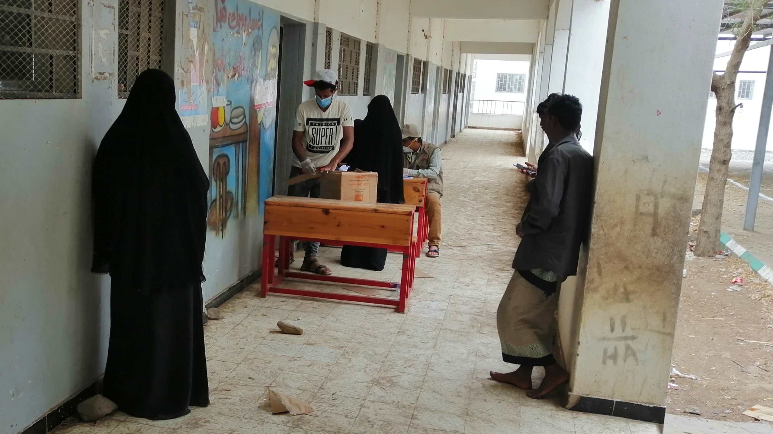 Women queuing at a distance from one another at a food distribution point in Yemen.